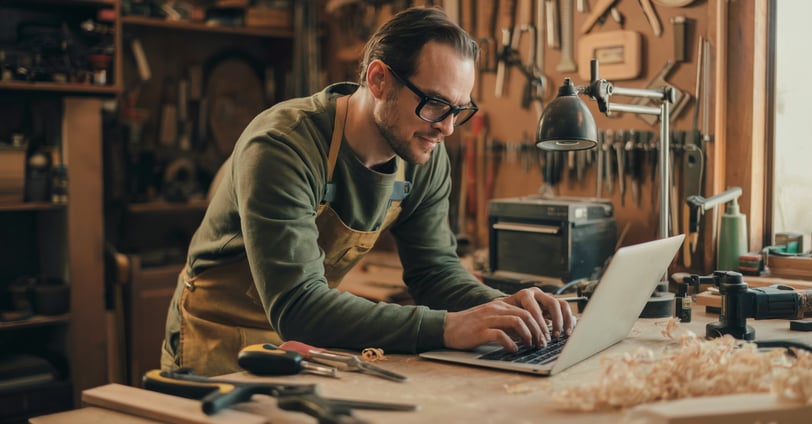 a man in a green shirt is working on a laptop