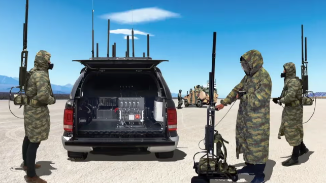 a man in camouflage gear standing in front of a van