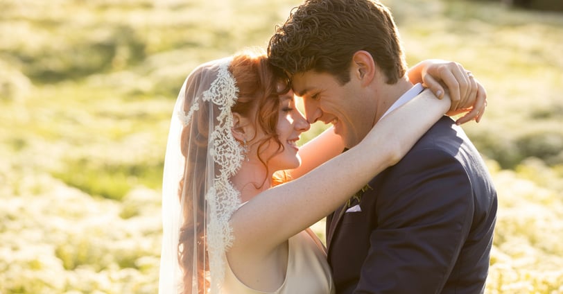 a bride and groom standing in a field
