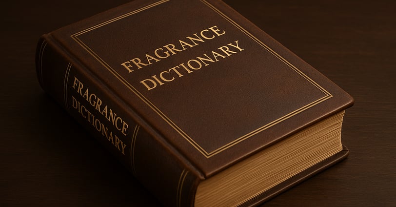 Hardcover book titled "Fragrance Dictionary" in gold text on a brown leather surface.