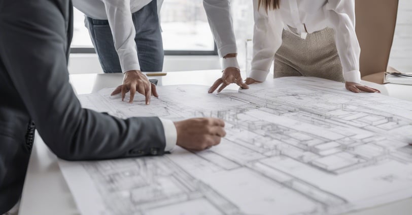 An architect discussing plans with clients, emphasizing the importance of personalized design