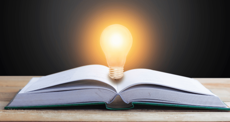 a book open book with a light bulb on top of it