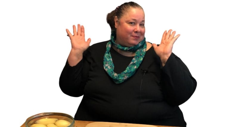 everyday dana with her hands up smiling at a table to show her weight loss journey in moderation