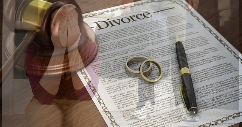 divorce papers with wedding bands on top of them