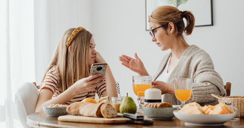 a woman sitting at a table with her child