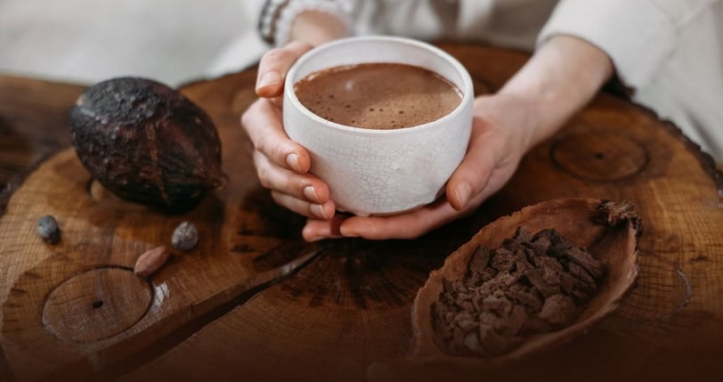 a person holding a cup of cacao elixir