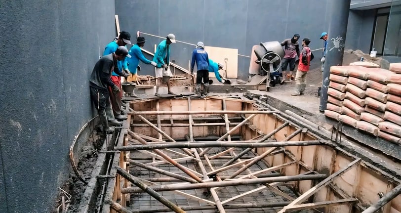proses pengecoran kolam renang di halaman belakang rumah.