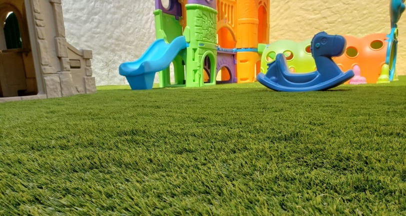 pasto sintetico instalado en una terraza infantil con juegos