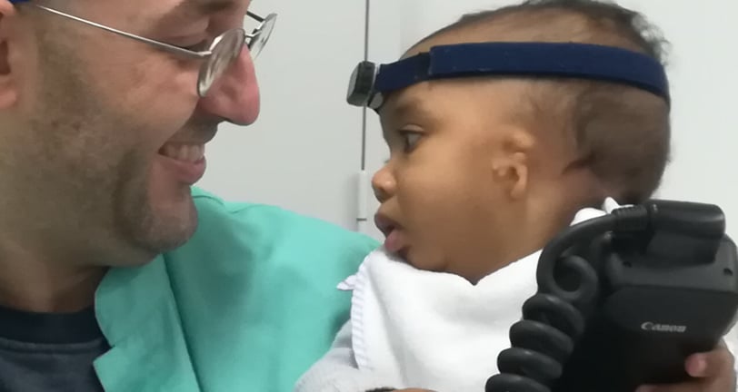a man in a blue shirt and a baby in a blue hat