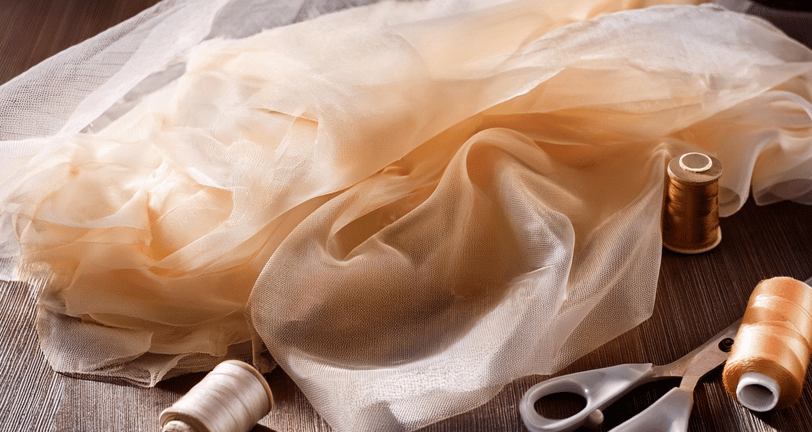 layers of sheer peach and creamy brown fabric with matching thread
