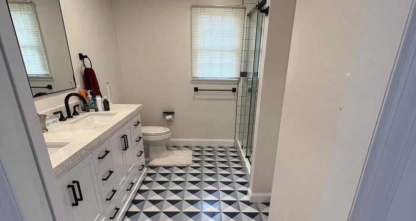 a bathroom with a black and white tiled floor