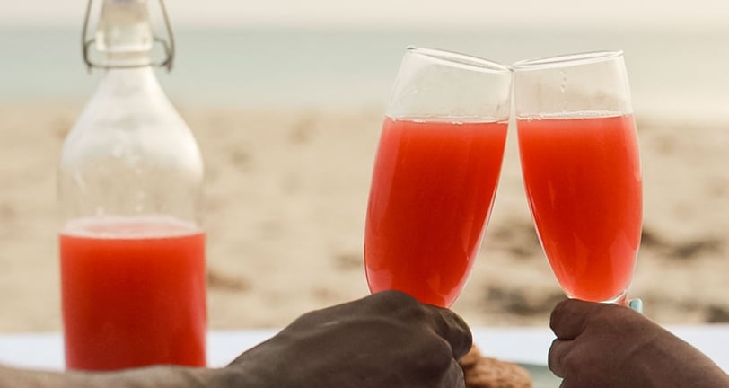 cheers two glasses clinking private beach dinner Barbados 