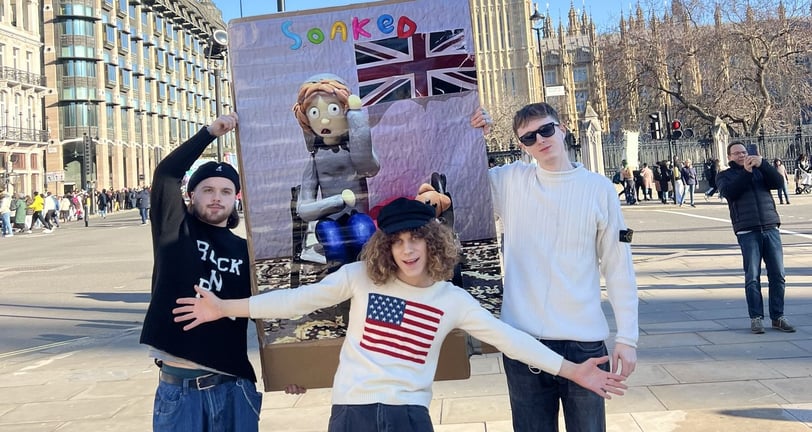 Soaked band holding Talk About It poster in front of Big ben