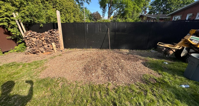 Professional stump removal using a grinder on a residential property in West Island