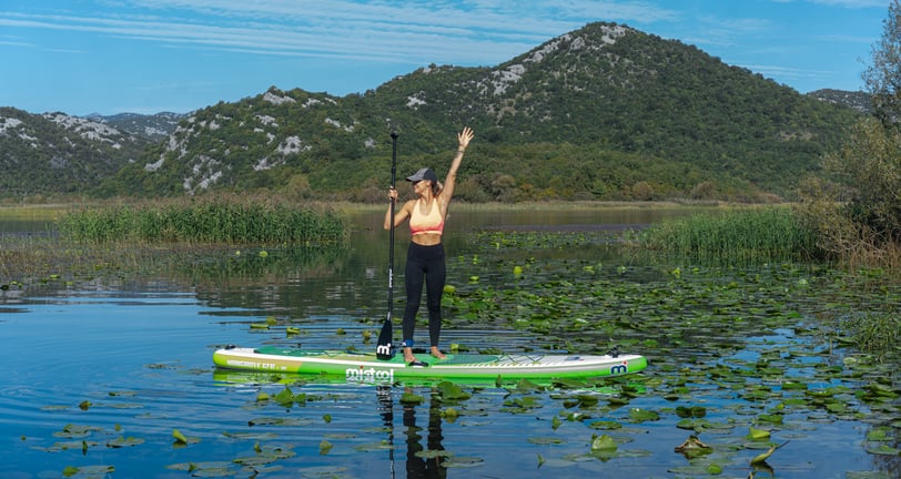 woman standing on sup on lake skadar