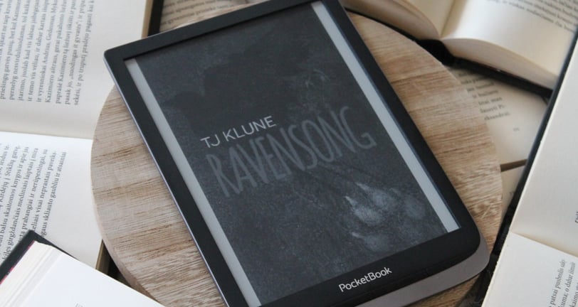 a book is sitting on a wooden table ravensong tjklune