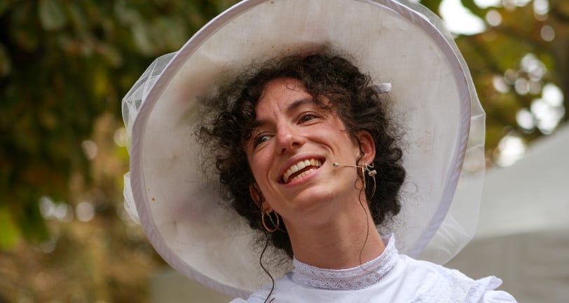 Aude Fy, chanteuse en tenue belle époque en train de chanter en concert en plein air