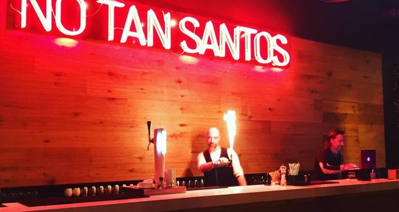 a bar with a neon sign that says no tan's on it