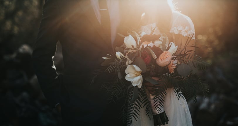 a bride and groom standing in front of a sunlit sunlit background