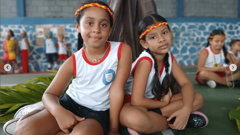 Duas alunas educação infantil centro educacional Florescer sentadas na quadra esportiva