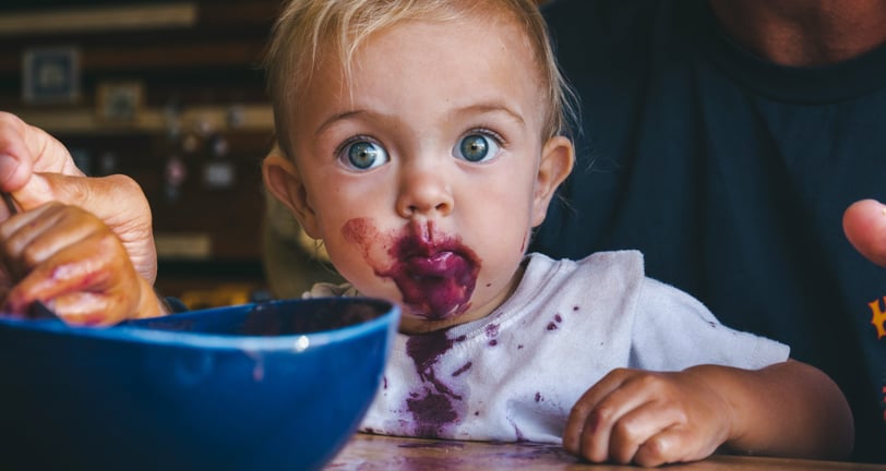 a baby eating a bowl of food