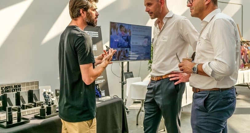 Groupe de personnes qui discutent autour d'un stand de produits de beauté pour les hommes