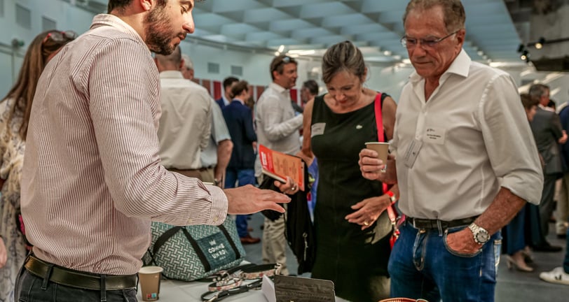 Deux hommes et une femme qui discutent autour d'un stand d'accessoires pour animaux de compagnie