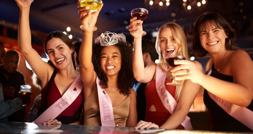 Bride-to-be and friends raising drinks during a fun-filled bachelorette night out on Fremont Street in Las Vegas.