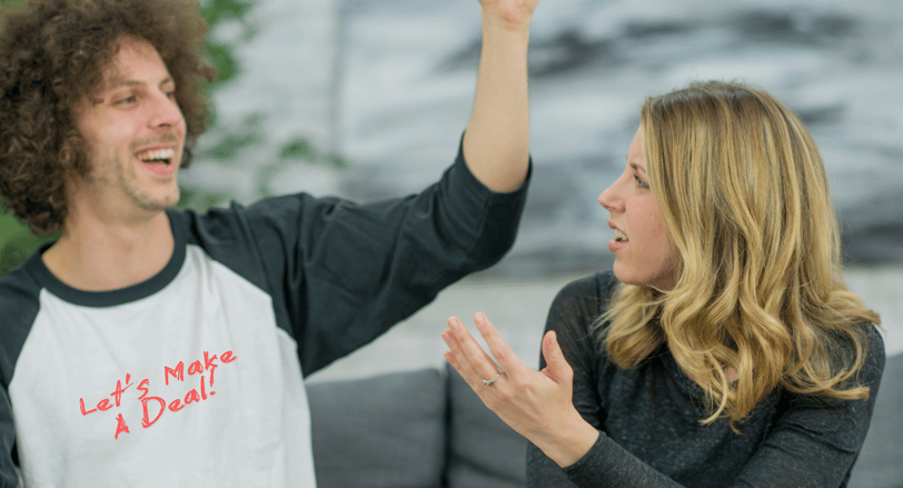 a man and woman are holding hands up in the air