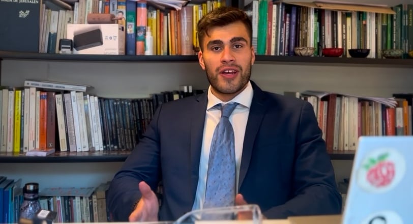 a man in a suit and tie sitting at a desk