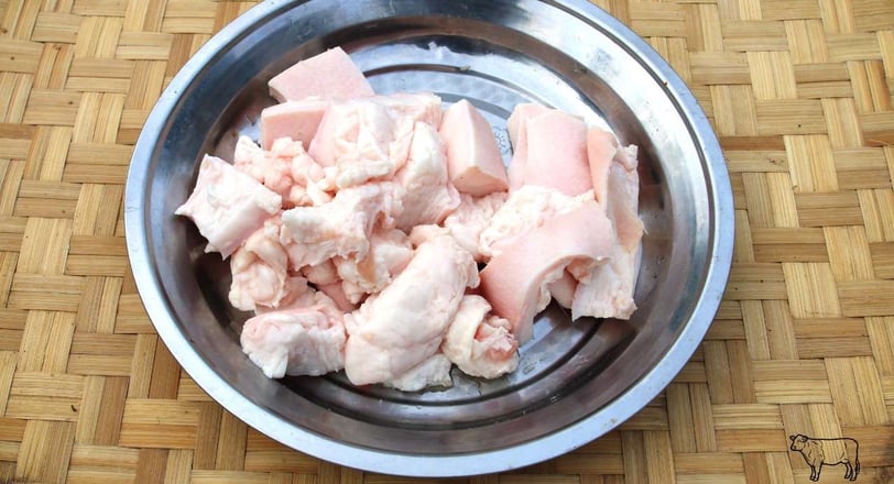 Raw beef fat chunks in a metal bowl, ideal for rendering into beef tallow for cooking or skincare purposes