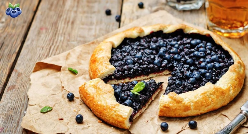 Freshly baked blueberry crostata with a golden crust and vibrant blueberry filling, served on rustic parchment paper