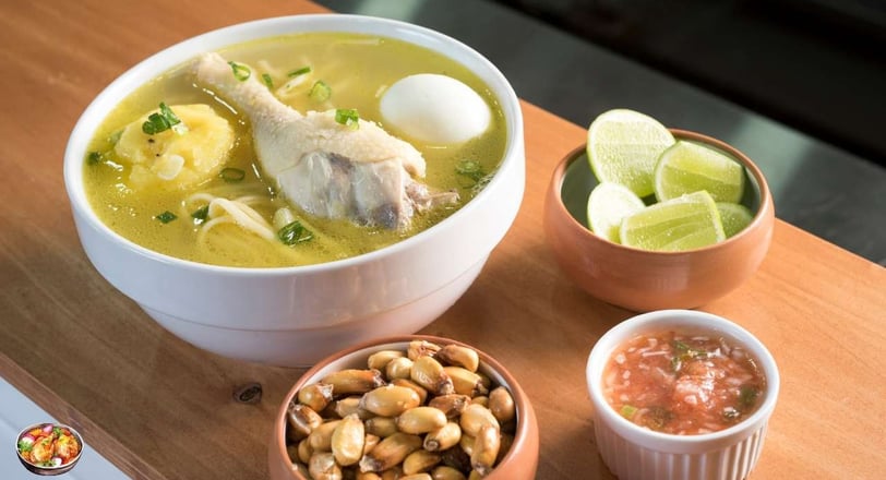 Caldo de pollo with chicken, vegetables, and sides of lime, salsa, and roasted corn nuts