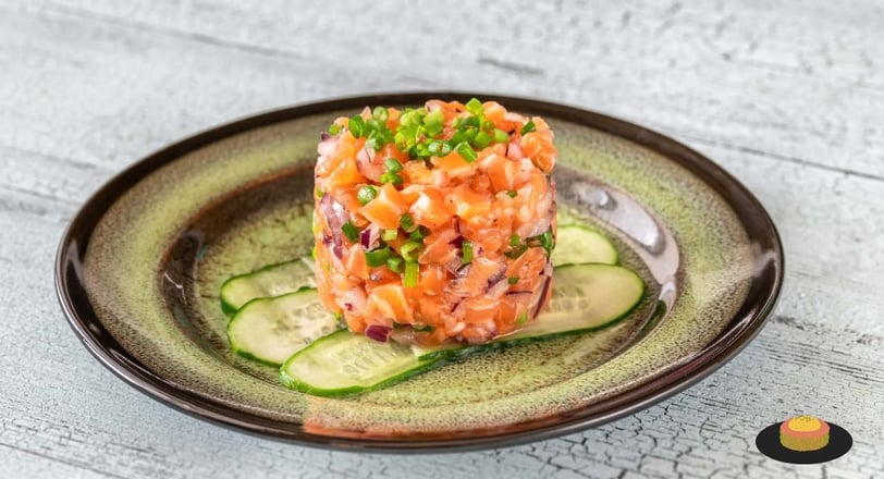 A beautifully plated salmon tartare garnished with fresh herbs and a side of lemon, showcasing a gourmet appetizer