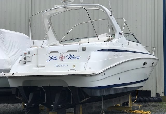 a boat sitting on a trailer with a boat in the background