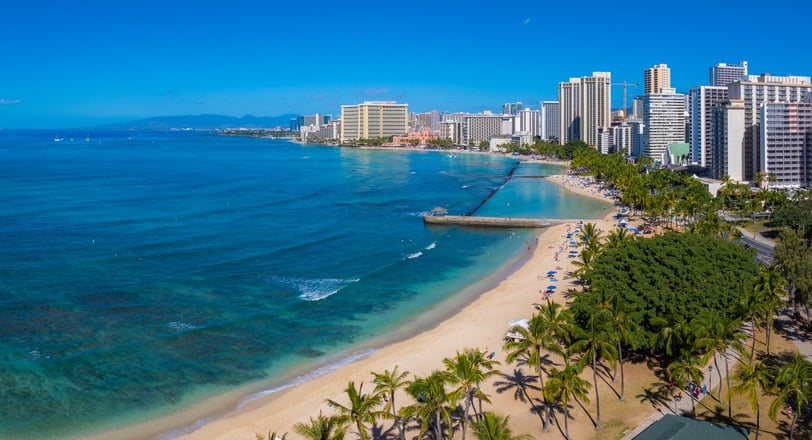 Turquoise waters meet sandy shores at Waikiki Beach,