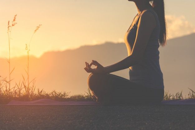 mulher meditando ao ar livre representando a meditação guiada para encontrar a paz interior 