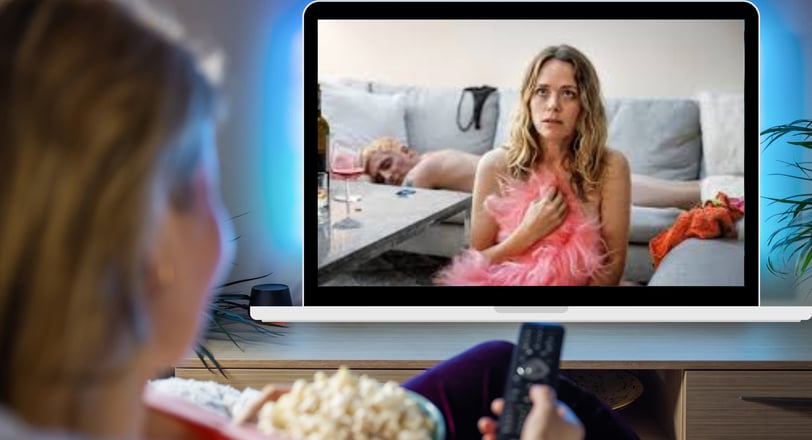 a woman watching a tv screen with a remote control