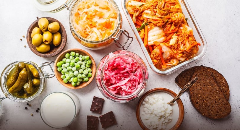 a table with a variety of fermented foods and probiotics in glass containers