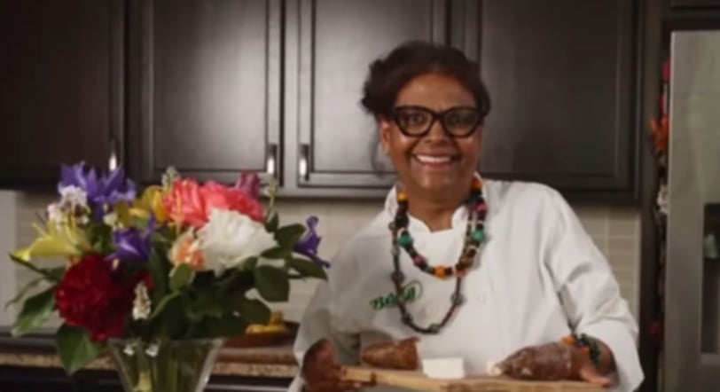 a woman in a white shirt and glasses is smiling