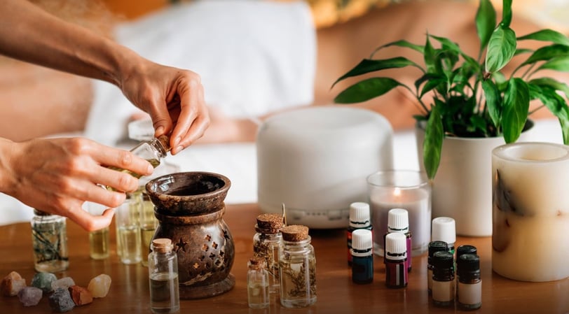 a person is holding a bottle of essential oils