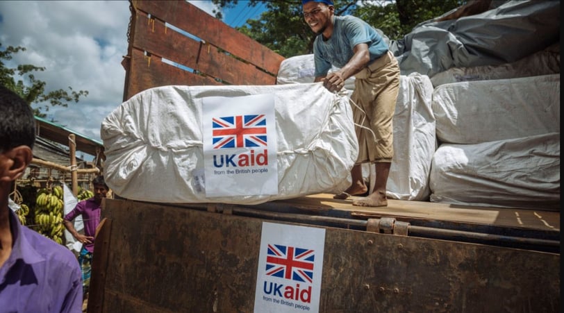 a man standing on a truck with a large pile of bags