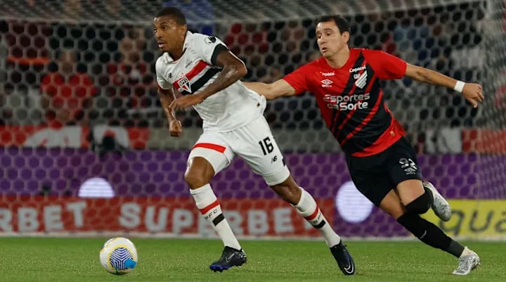 two men playing soccer on a field