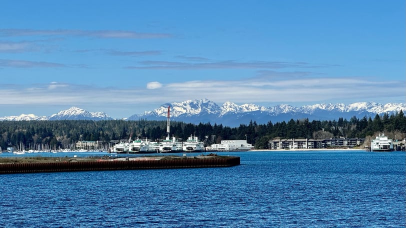 Multiple ferries on Bainbridge Island with the Olympics in the background