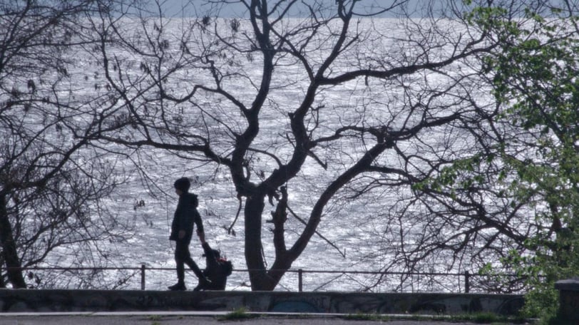 a man walking down a sidewalk with a dog