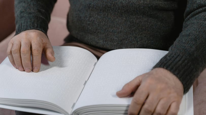 A person reading a large book, written in braille.