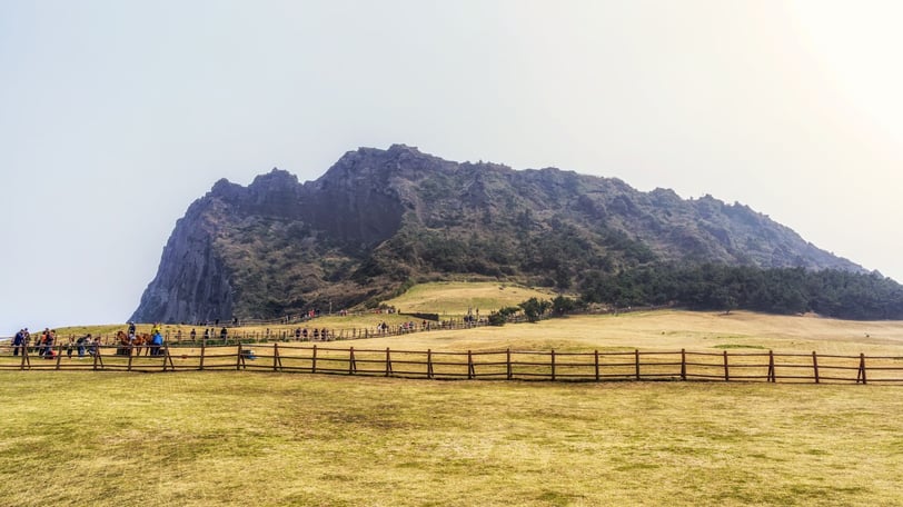 Formação vulcânica de Seongsan Ilchulbong vista da trilha, com suas encostas verdes.