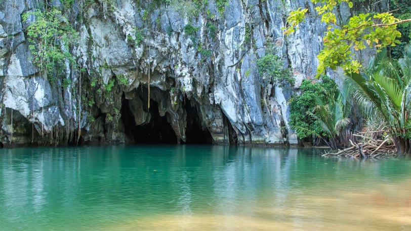 Entrada do rio subterrâneo de Puerto Princesa, com formações rochosas ao redor.