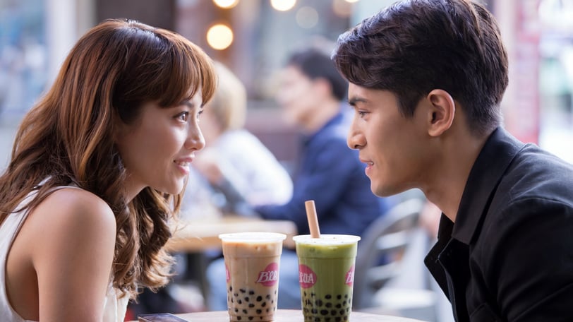 a man and woman sitting at a table with drinks