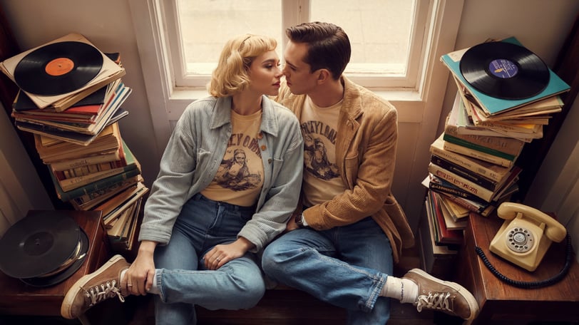 a man and woman sitting on a bench in front of a window